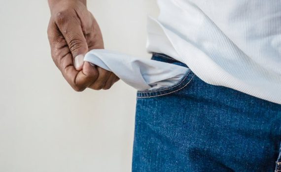 person in blue denim jeans holding white textile