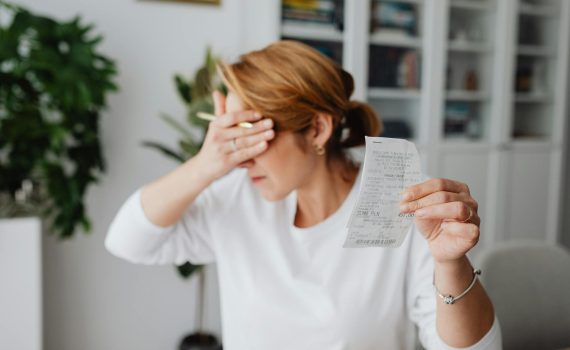 unhappy woman holding bill