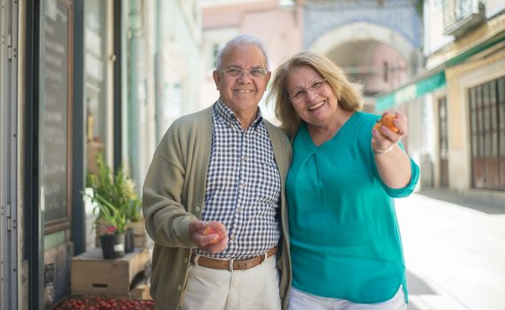 smiling elderly couple buying groceries