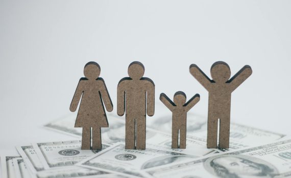 wooden family dolls on cash